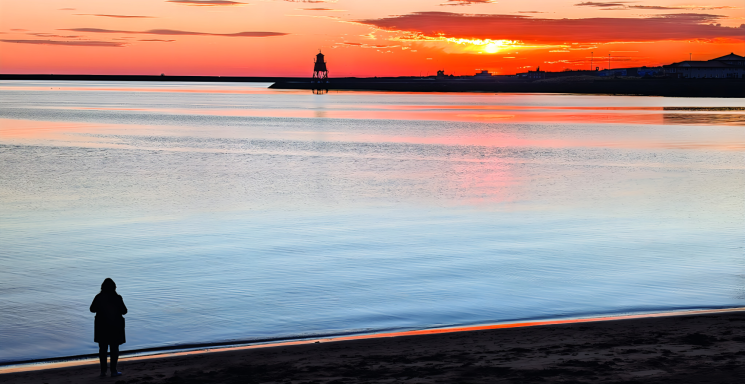 Lady gazes upon dawn of a Christmas sunrise-South shields